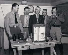DPS Director Homer Garrison (on the far left) and several unknown law enforcement officers demonstrate an early breath alcohol test (circa 1938).