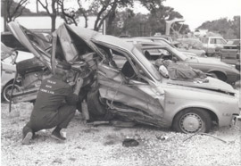 An unnamed Crime Lab employee processes a wrecked car. This photo was undated, but we believe it was probably taken sometime in the 1970s.